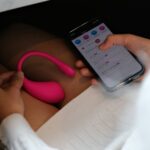 a person holding a cell phone with a pink handle