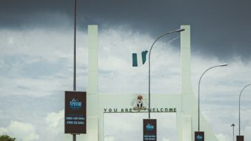 A car driving down a highway under a cloudy sky