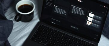 black laptop computer on white textile