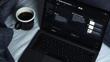 black laptop computer on white textile