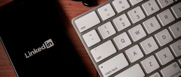 a cell phone sitting next to a keyboard on a table