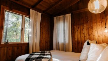 a bed in a room with wooden walls