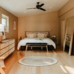 A bedroom with a bed, dresser, and a window