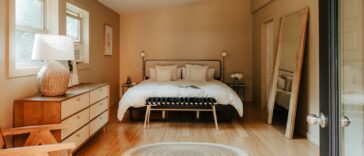 A bedroom with a bed, dresser, and a window