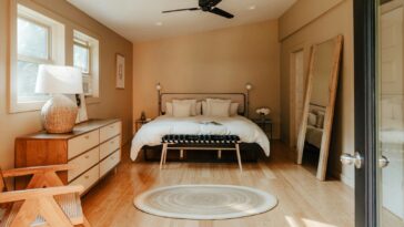 A bedroom with a bed, dresser, and a window